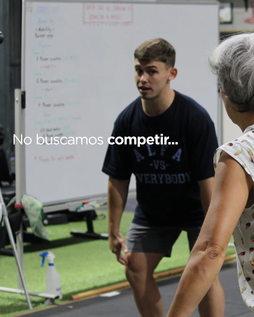 Coach acompañando a una socia mayor durante el entrenamiento en Alfa Box Tudela: no buscamos competir
